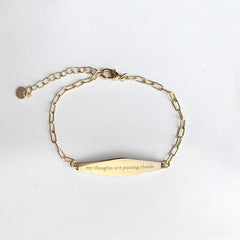 Gold Paper Clip Mindfulness Bracelet Engraved with the phrase "my thoughts are passing clouds"